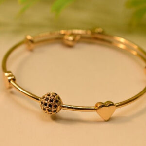 Gold bangle bracelet with heart-shaped charms and a detailed bead.
